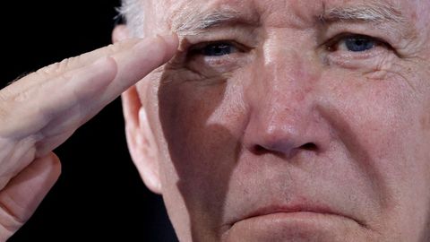 Joe Biden salutes during a military ceremony in Washington