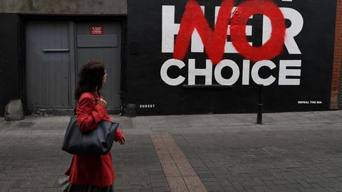 Una mujer camina frente a un grafitti antes del referndum del 25 de mayo sobre la ley del aborto en Dubln