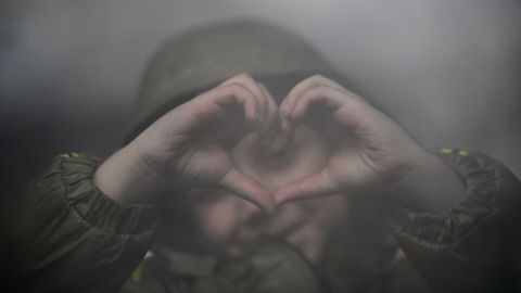 Y la ilusión de los niños. Cómo este. Con el gesto de un corazón simboliza la esperanza de lo que está por llegar lejos de la guerra. Lo hace mientras espera en la estación de Nyugati.