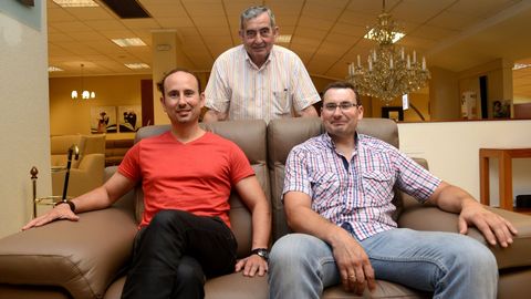 Roberto Torres, de rojo, con su hermano y con su padre en el negocio familiar