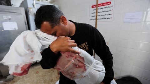 Un hombre palestino llora mientras sostiene el cuerpo de un nio muerto, en Gaza.