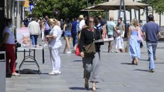 Una mujer paseando sin mascarilla frente a la Diputacin de Lugo