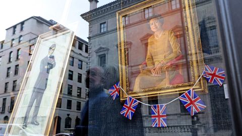 The window of the London art gallery with portraits of Elizabeth II.  and Charles III