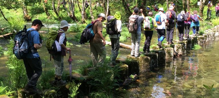 Senderistas cruzan el río Tea por el paso pétreo de Lourido en Covelo. El de Tatín, en Mondariz, era impracticable porque el río va crecido. 