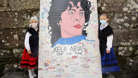Das cativas posan cun cartel da poetisa Xela Arias homenaxeada o Da das Letras Galegas en Cambados.
