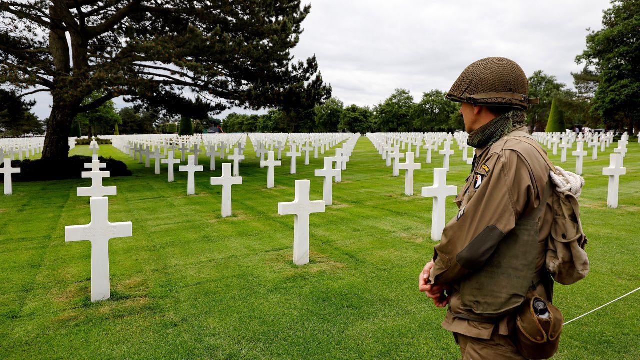  Un hombre que luce un uniforme militar estadounidense de poca observa las tumbas en el cementerio galo de los soldados cados estadounidenses en Colleville-Sur-Mer 