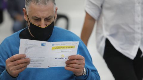 Un paciente lee el folleto informativo de la vacuna de AstraZeneca en el Ifevi de Vigo