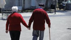 Una pareja mayor pasea agarrada de la mano por Oleiros (A Coruña)