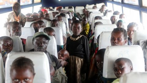 Las familias congoleas que huyeron de los enfrentamientos tnicos en la Repblica Democrtica del Congo en un bote al otro lado del lago Alberto, se sientan en un autobs al llegar al campamento de asentamientos del Alto Comisionado de las Naciones Unidas para los Refugiados (ACNUR) en Kyangwali, Uganda