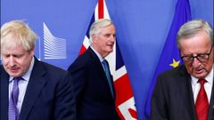 Barnier pasa por detrás de Johnson y Juncker, antes de la rueda de prensa en la que anunciaron el acuerdo