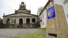 Fachada principal de la iglesia de Vilabade, en Castroverde, junto a una señal indicadora del Camino Primitivo