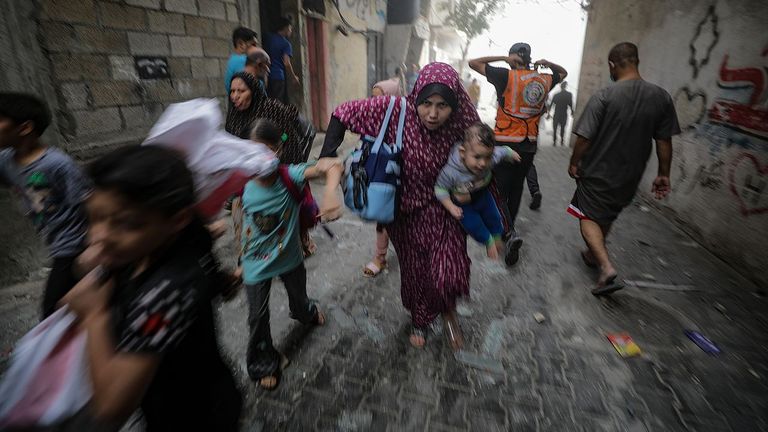 Palestinos huyen con sus hijos en brazos de los ataques israelíes