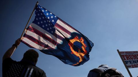 Un seguidor de Trump enarbola una bandera con el símbolo de la secta QAnon, promotora de una teoría de la conspiración en Estados Unidos