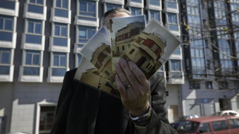 Una vivienda por nada: Vicente, delante de uno de los dos edificios a subasta, muestra las fotos de la que fue su casa en Vioño. Se encontraba en una de las esquinas que ocupa el bloque residencial de siete alturas y todavía pendiente de terminar desde el 2000