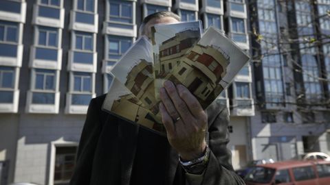 Una vivienda por nada: Vicente, delante de uno de los dos edificios a subasta, muestra las fotos de la que fue su casa en Vioo. Se encontraba en una de las esquinas que ocupa el bloque residencial de siete alturas y todava pendiente de terminar desde el 2000