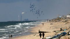 Ayuda lanzada desde el aire cae sobre un playa de Gaza.