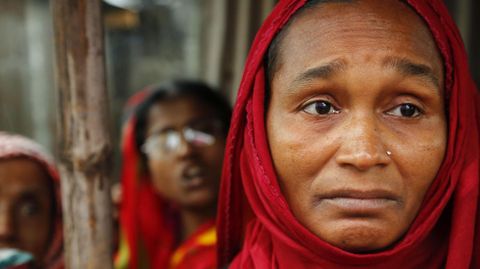 Hosneara Begum, madre de un trabajador fallecido en el derrumbe del complejo textil Rana Plaza, se concentra delante del lugar donde se levantaba el edificio por el cuarto aniversario de la tragedia en Dacca (Bangladesh) 