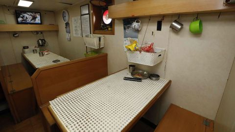 Televisin, con conexin por satlite, y dos mesas en el comedor del barco