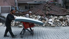 Vecinos de Hatay recuperan sus pocas pertenencias de los escombros de sus hogares.