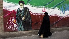 Una mujer pasea frente a un mural del ayatol Jomeini en Tehern.