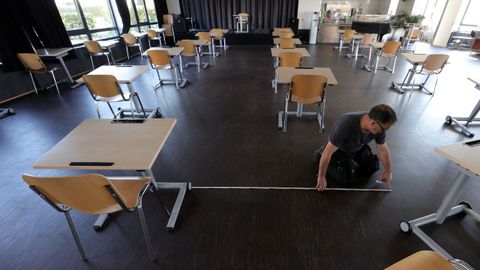 Un empleado de una escuela trabajando en el vestíbulo para reconvertirlo en un aula, en Dortmund (Alemania)