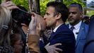 Emmanuel Macron, este domingo, besando a un simpatizante a las puertas de su colegio electoral