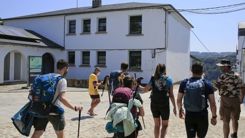 Peregrinos pasando ante el albergue municipal de Portomarín, utilizado para casos de aislamiento
