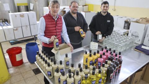 Rubén Rivas, José Antonio Mon y Jonathan Rivas con las botellas en la fábrica
