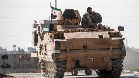 Combatientes sirios respaldados por Turqua trasladan vehculos blindados hacia la frontera siria 