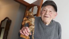 Lino Suárez Piñón, con un tigre tallado en madera por él mismo desde su casa en Cedeira