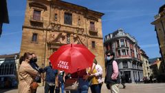 Un grupo de turistas atienden las explicaciones de un gua en la plaza del Ayuntamiento de Oviedo
