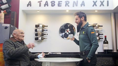El sargento Alberto charla con un vecino de Carral mientras toma café, una interacción fundamental en el trabajo de los agentes
