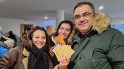Tres personas muestran sus preciadas entradas para la Festa do Botelo.