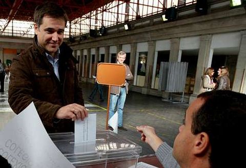 Moreira, votando en las autonmicas del 2012, observado de lejos por Alfonso Rueda.