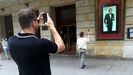 Dos hombres fotografían la efigie de Arturo Fernández en la fachada del Teatro Jovellanos de Gijón