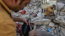 Un palestino corta el pelo a un niño entre las ruinas de un edificio en Gaza