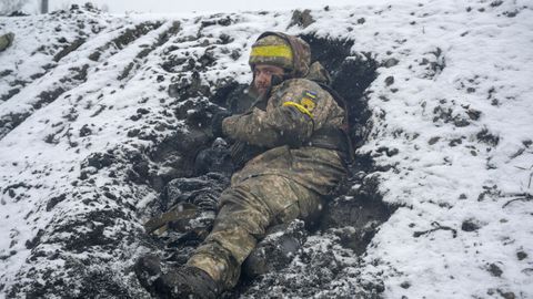 Un militar ucraniano yace en el suelo en una posición de combate en Kharkiv, Ucrania.