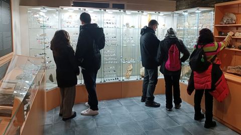 Un grupo de visitantes observando los minerales recién incorporados a los fondos del museo de geología de Quiroga
