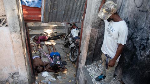 Un vecino de Puerto Prncipe observa unos cadveres en una casa abandonada.