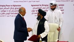 Los representantes de Estados Unidos (izquierda) y de los talibanes tras suscribir el histrico acuerdo de paz en Doha