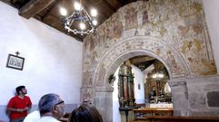 Un grupo de visitantes admira las pinturas de la iglesia de Seteventos en una visita guiada