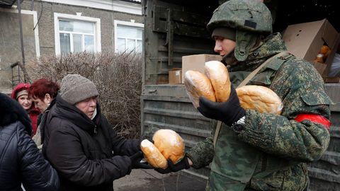 Un soldado prorruso reparte pan en una localidad de Donetsk controlada por los separatistas