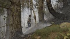  Un hombre trabaja en las labores de extincin del incendio declarado en Navelgas, Asturias