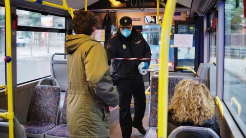La Polica Nacional reparti mascarillas a pasajeros del transporte urbano