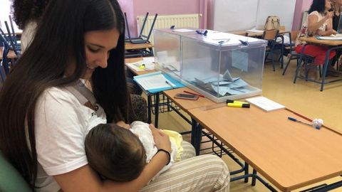 La presidenta de una mesa electoral de Arahal (Sevilla) amamanta a su hijo durante la votacin