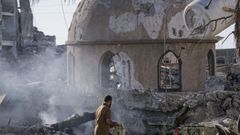 Un palestino recoge un Corn de las ruinas de un mezquita en la Franja.