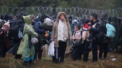 Un grupo de inmigrantes espera en suelo bielorruso cruzar hacia Polonia.