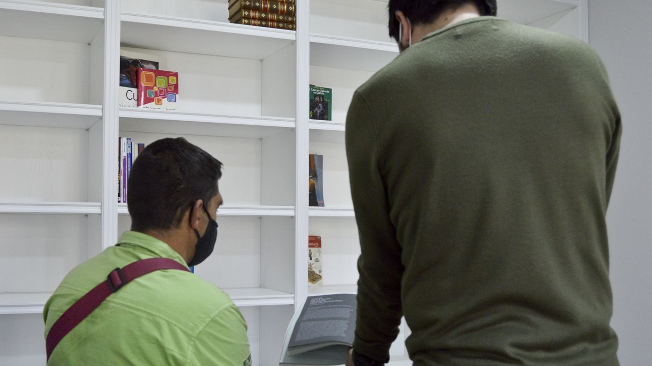 El coordinador del centro de atención social de Rexurdir, ayer, mostrando un libro a un usuario