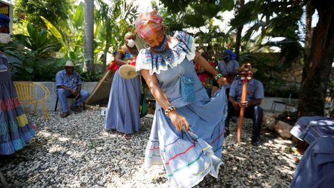 Una sacerdotisa vudú baila con una mascarilla durante una ceremonia en Puerto Príncipe