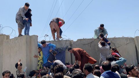 Cientos de afganos saltaron el muro del aeropuerto internacional de Kabul, Hamid karzai en Kabul, el 16 de agosto, en un intento de poder abandonar el país después de que los talibanes tomaran control de la capital. 